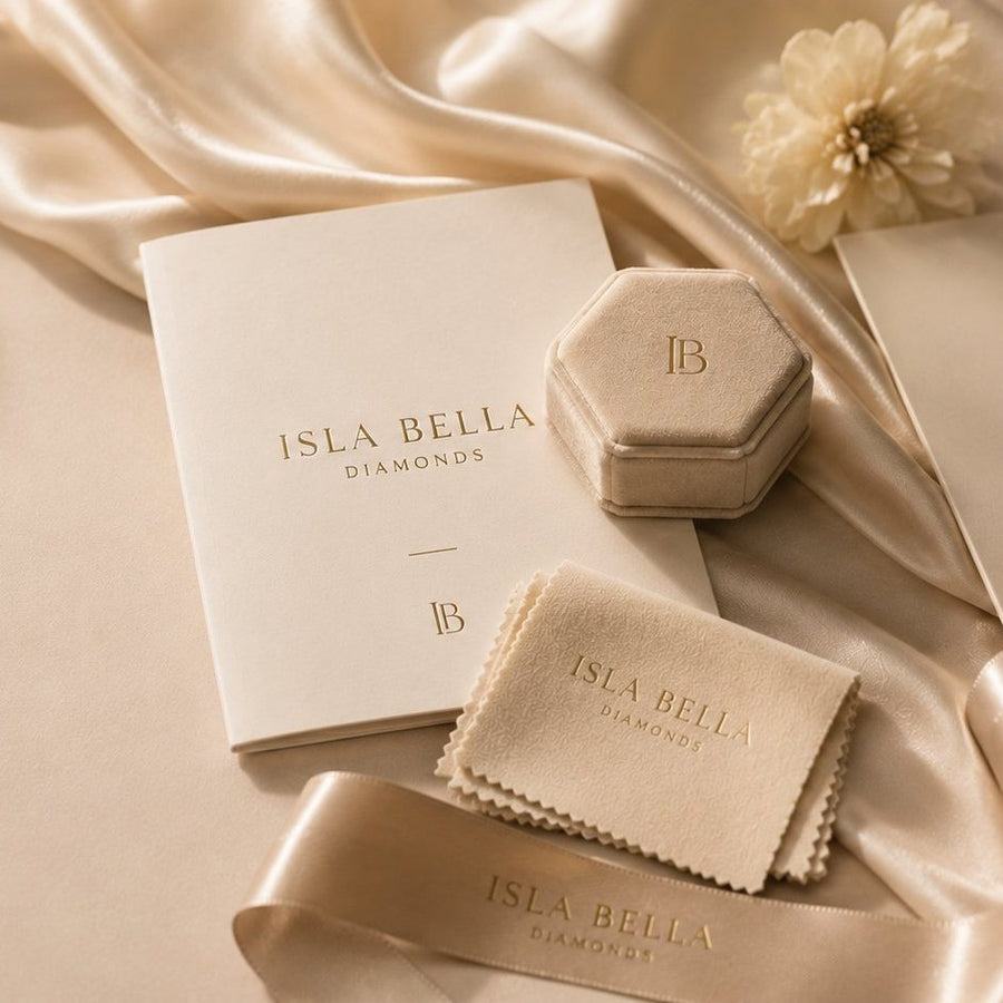 Isla Bella Diamonds luxury packaging — a hexagonal ring box, branded gift folder and polishing cloth resting on champagne silk.